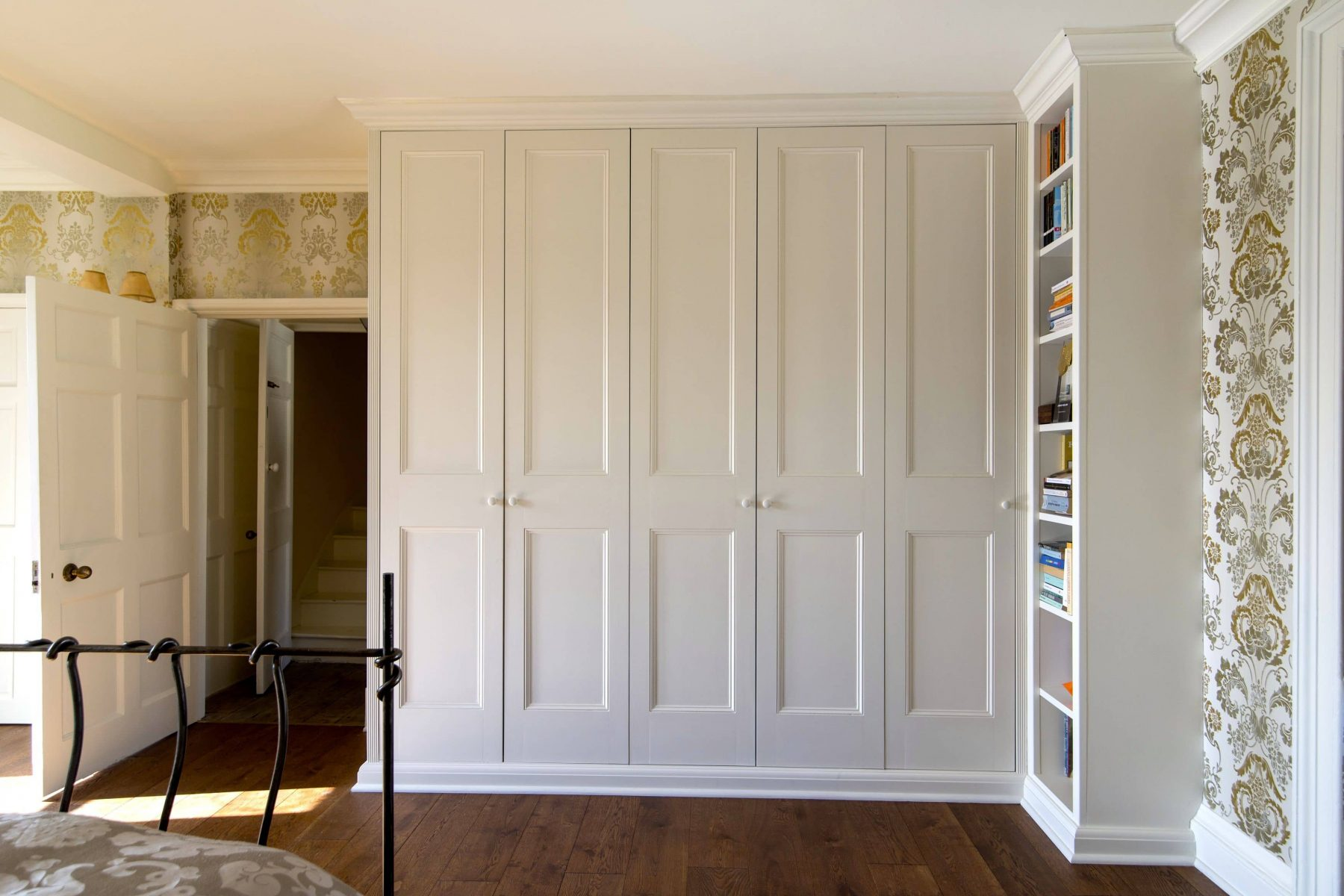 Classic white panelled fitted wardrobes with bookcase